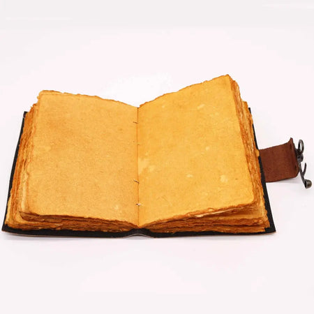Open leather notebook with lotus mandala design, brown strap, and aged golden-yellow handmade paper pages