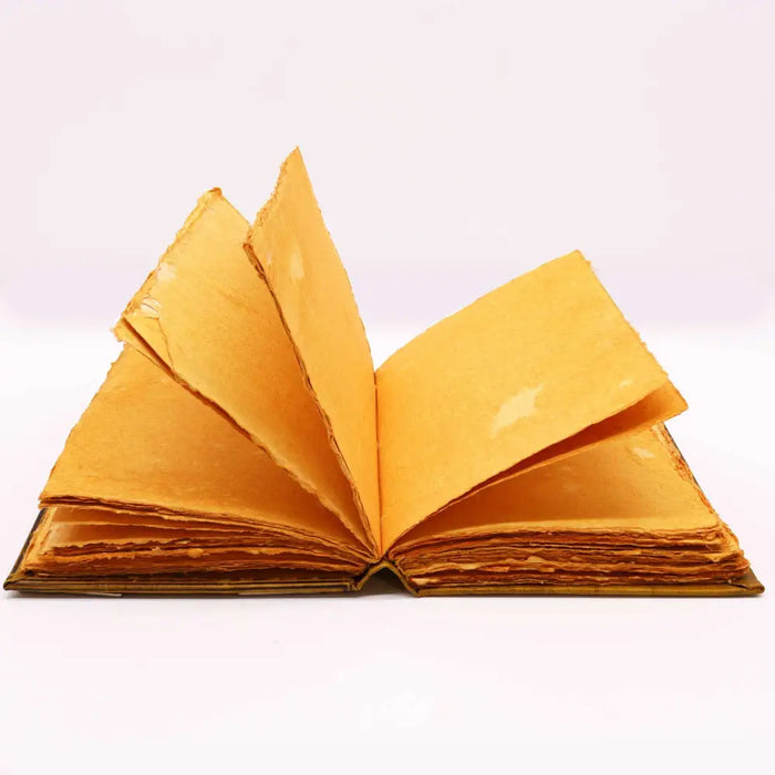 An open leather notebook with aged golden yellow pages and a worn textured cover sized 10 by 7 inches