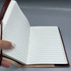 A burgundy leather notebook with leather cover, lined white pages, and visible stitching, sized 8 by 6 inches