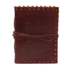 Brown leather notebook with stitched edges and wrap strap embossed with the book of thoughts text