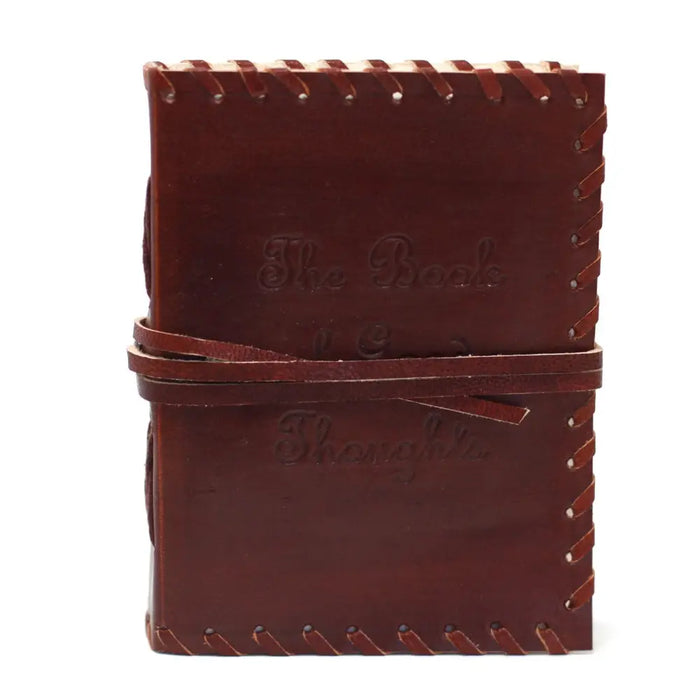 Brown leather notebook with stitched edges and wrap strap embossed with the book of thoughts text
