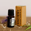 A dark amber glass essential oil bottle with a black cap labeled less stress essential oil blend with lemon and lavender