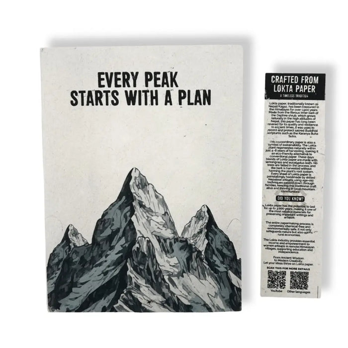 A black-and-white lokta paper notebook with mountain design and text every peak starts with a plan on the cover
