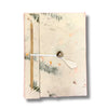 A handmade lokta paper notebook with mixed flowers pattern on off-white cover, bamboo spine, and wooden button closure