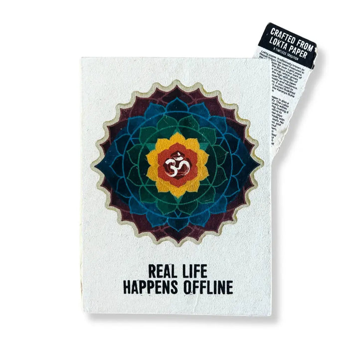 A white lokta paper notebook with a colorful mandala and om symbol, titled real life happens offline 8 by 6 inches