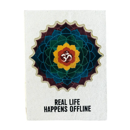 A textured white lokta paper notebook with a colorful mandala and om symbol titled real life happens offline