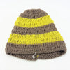 A hand-knitted loose knit oversized beanie hat with bright yellow and muted brown stripes and a ribbed pattern