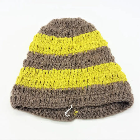 A hand-knitted loose knit oversized beanie hat with bright yellow and muted brown stripes and a ribbed pattern