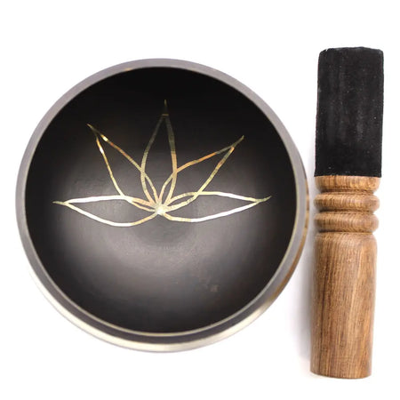 Black tibetan lotus flower singing bowl with gold lotus design made of metal, shown with a soft ring pillow underneath