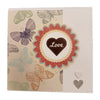 A cream greeting card with a brown heart saying love surrounded by red and beige scalloped borders from milford haven