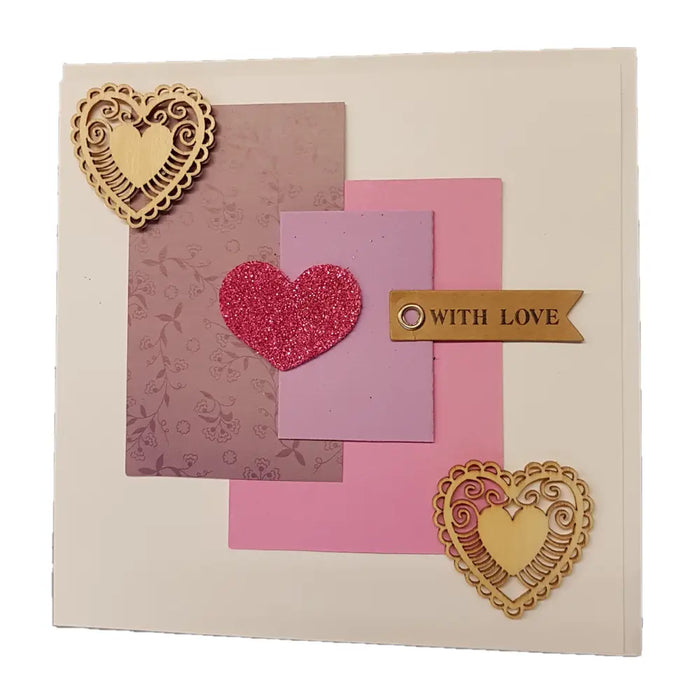 A pink glitter heart on a layered love themed greetings card with wooden hearts and a with love banner milford haven