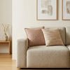 Beige textured fabric sofa with two decorative pillows featuring a burgundy squares cushion cover and multicolored weave