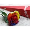 A luxury single soap flower shaped like a vibrant rainbow rose with layered red orange yellow green blue purple petals