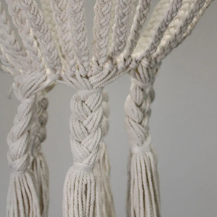 Cream-colored cotton rope chandelier with intricate braided design and tassels in natural cotton rope material