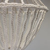 A delicate off-white macrame large drop cotton rope chandelier with an intricate woven pattern and cotton rope material