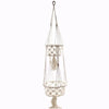 Cream-colored macrame pot holder with double tiered circular baskets made of cotton rope and decorative tassels
