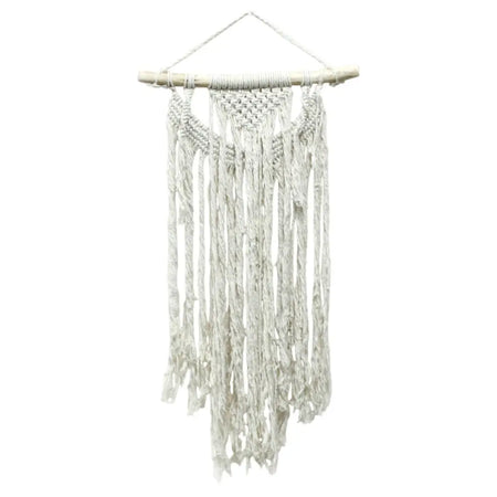 A white macrame wall hanging with wooden dowel and fringed tassels in a boho style for home decor