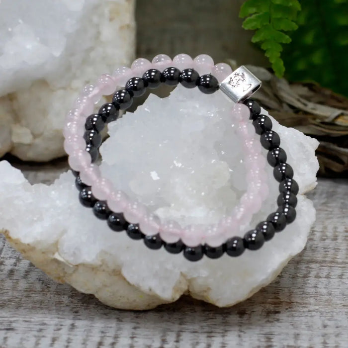 Magnetic gemstone bracelet with double strands of pink rose quartz and black onyx beads and a silver engraved clasp
