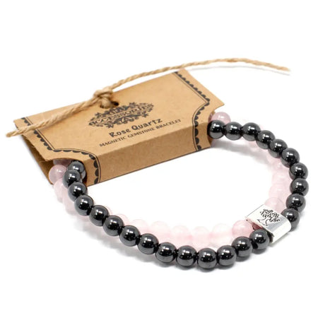 A magnetic gemstone bracelet with rose quartz and black beads featuring a silver toned tree design accent