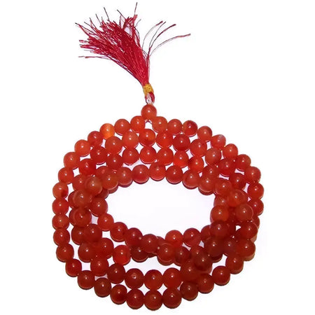 A coiled string of smooth translucent carnelian mala beads in orange-red with a matching red tassel