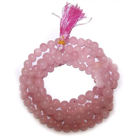 A delicate pink rose quartz mala beads bracelet with matching tassel made from smooth stone beads