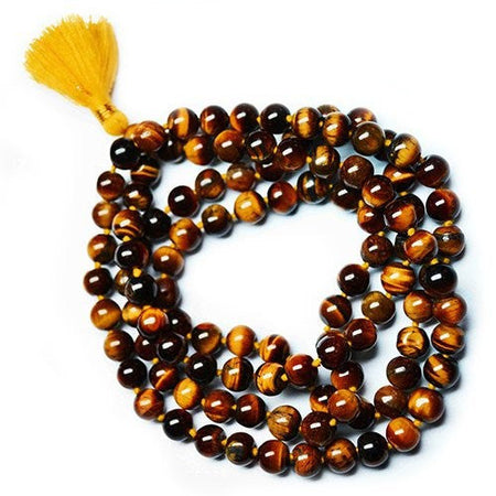 A coiled string of polished tiger eye mala beads with a bright yellow tassel at one end