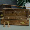A rustic mango wood smoke box with a carved elephant design and perforated lid featuring golden accents