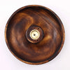 A dark brown mango wood incense burner disc with a brass center piece for wood incense sticks and cones