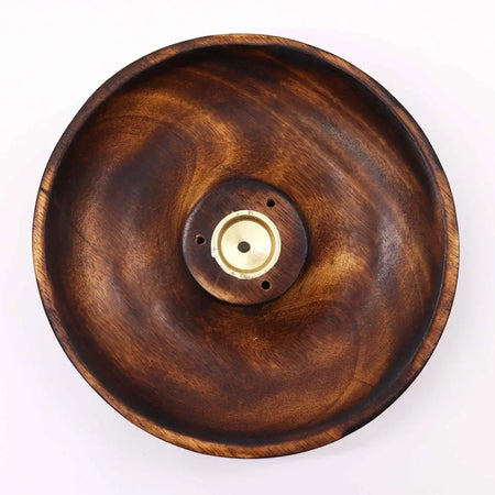 A dark brown mango wood incense burner disc with a brass center piece for wood incense sticks and cones