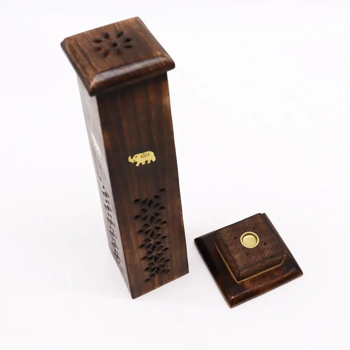Dark brown mango wood tapered square incense tower with floral carvings and a gold elephant emblem on a matching base