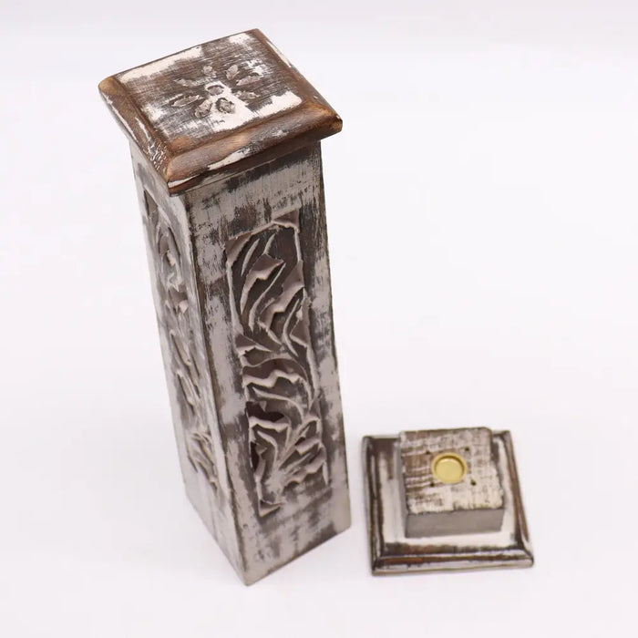 A rustic mango wood incense tower with a whitewash finish and carved leaf patterns on tapered square sides