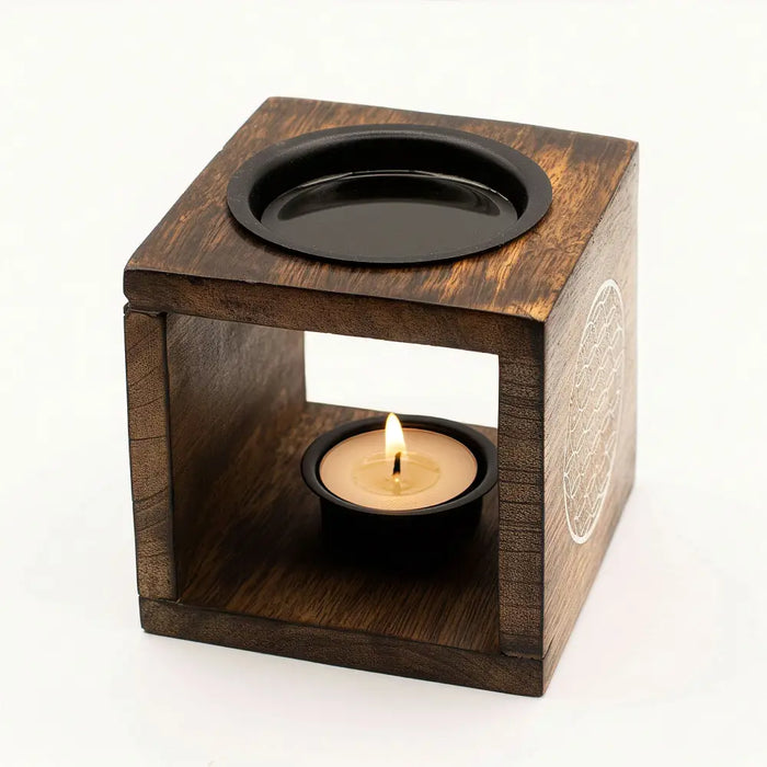 Dark mango wood oil burner cube with black top and white mandala design holding a lit tea light candle inside