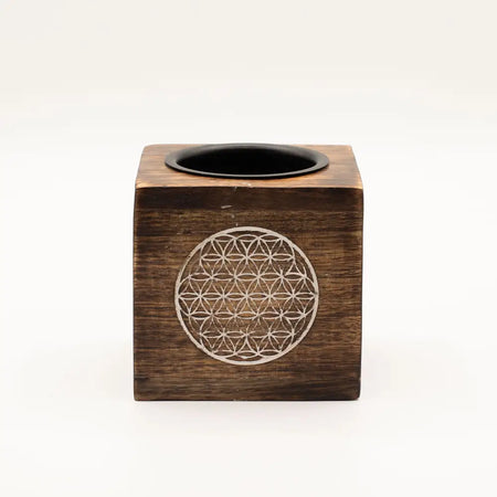 Dark brown mango wood oil burner cube with a carved white flower of life design and black circular opening