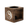 Dark brown mango wood oil burner cube with white yin yang symbol and two black circular holders for oil or candles