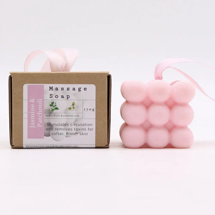Pink cube-shaped massage soap with soft bubbly texture and jasmine and patchouli scent tied with pink ribbon