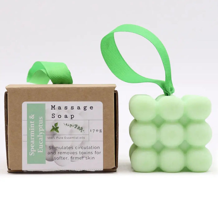 Light green cube-shaped massage soap with textured surface and spearmint eucalyptus scent and hanging ribbon loop