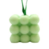 A pale green cube-shaped massage soap with bubbly texture and a matching green ribbon for spearmint and eucalyptus use
