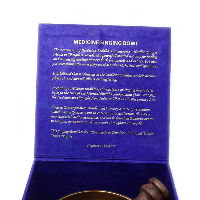 A golden medicine buddha singing bowl made of metal in a deep blue velvet box handcrafted in nepal