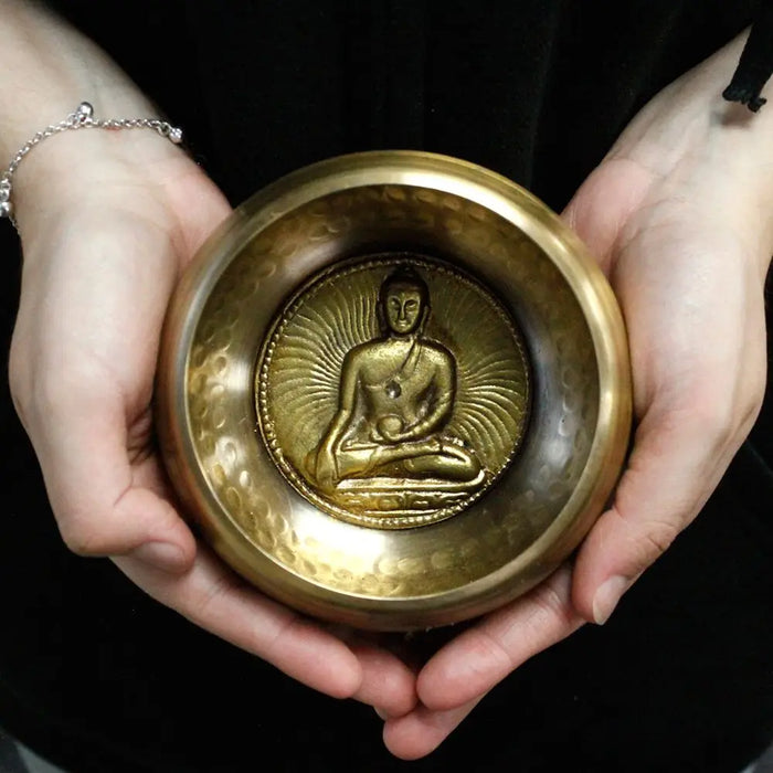 Golden brass medicine buddha singing bowl 10cm with detailed embossed buddha figure at the center