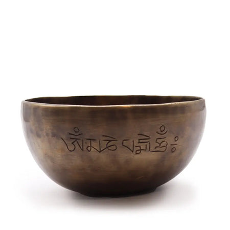 A medium bronze indian moon phase singing bowl with engraved sanskrit and tibetan script on the surface