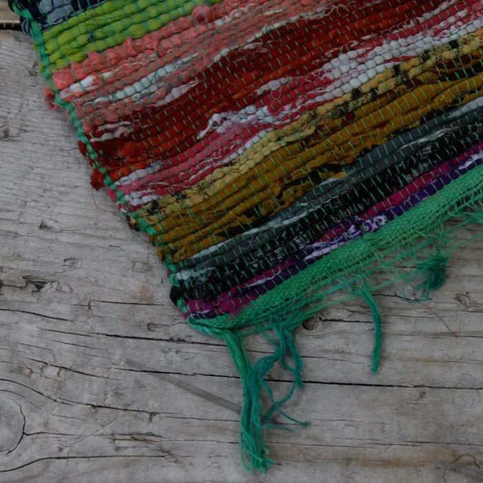 Medium rag rug green made from handwoven recycled fabric strips with multicolored frayed edges textured weave rag rugs