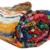 Medium natural rag rug with vibrant multicolored woven stripes and frayed edges handcrafted from fabric strips