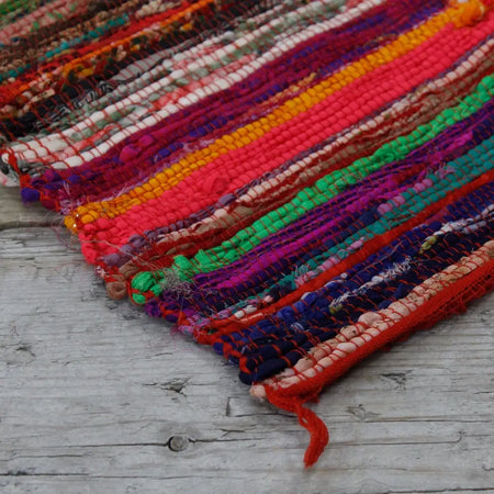 Medium rag rug with bold red and multicolored handwoven stripes made from soft cotton rag rugs material