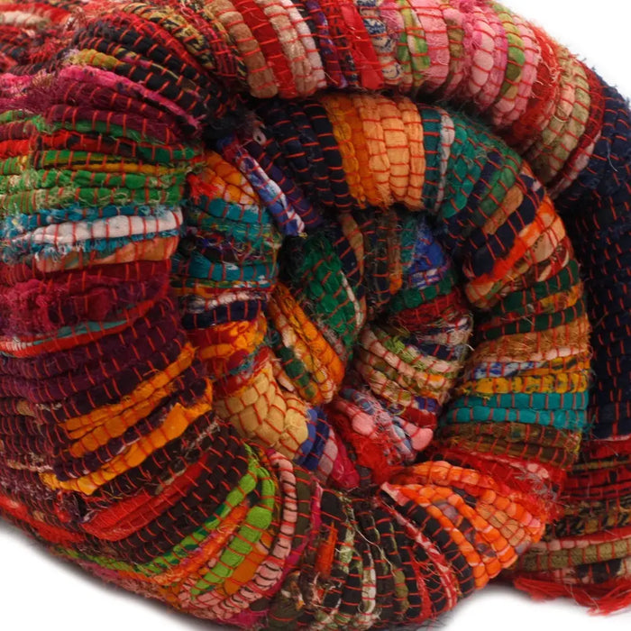 Medium rag rug made from handwoven multicolored fabric strips in reds, greens, oranges, and blues rag rugs