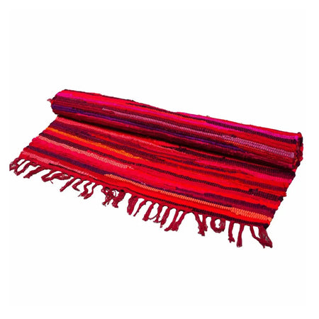 A medium rag rug in vibrant shocking pinks with horizontal stripes and fringed edges made from woven fabric