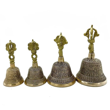 Four medium tibetan tingsha bells made of brass with intricate engravings and decorative multi pronged tops