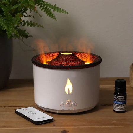 White cylindrical aroma diffuser with cracked black top and orange flame light showing flame design on front panel
