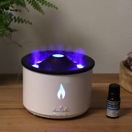 White cylindrical medium volcano effect aroma diffuser with black top emitting purple light and blue flame icon on front