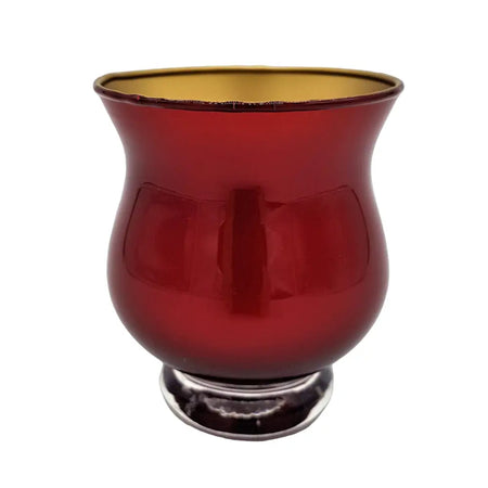 A metallic red glass tealight holder with a gold interior and silver toned base for holding candles