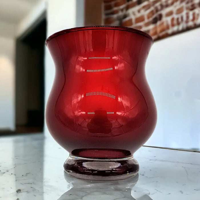 Metallic red glass tealight holder with a flared rim and etched lines featuring a gold interior finish
